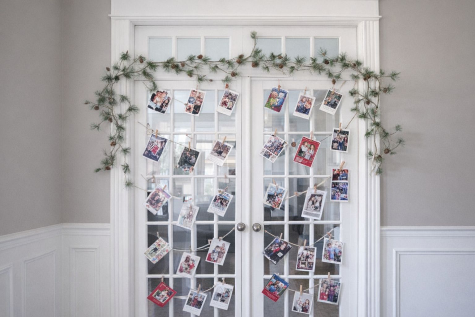 Vita dubbeldörrar prydda med julkort och barngirlang.